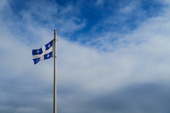 Flag of Quebec floating in the blue sky