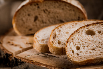 Freshly baked bread cut into chunks on a wooden Board