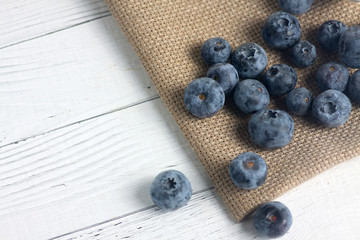 a pile of blueberry on canvas napkin on wooden table. Flat lay