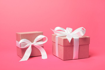 Trendy attractive minimalistic gifts on the coral pink background. Women's Day, St. Valentine's Day, Happy Birthday and other holidays concept.