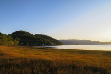 Beautiful sunrise over a golden field at L'Anse Saint-Jean in the Saguenay Fjord