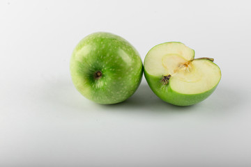 Whole and half green apple isolated on white. 