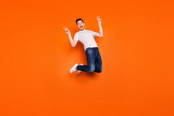 Fototapeta na wymiar Full size photo of positive cheerful guy jump enjoy spring free time holidays make v-sign wear casual style stylish outfit gumshoes isolated over bright color background