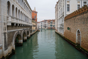 Fototapeta na wymiar Canal poco concurrido en la ciudad de Venecia solitaria. Reflejos en el agua. 