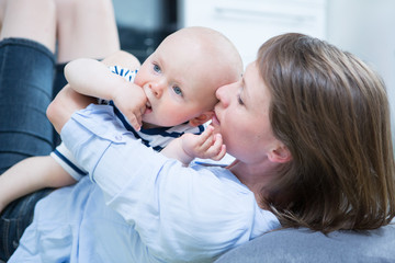 Happy mother playing with her baby at home