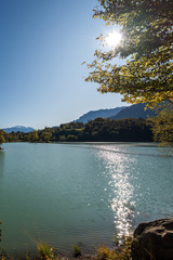 Lago di Tenno in autumn, small beautiful lake in backlight, Italian Alps. Trento province, Trentino-Alto Adige, Italy, Europe