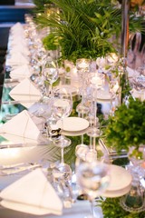 Palm tree leaf wedding table. Candles, napkins and mirrored tables.
