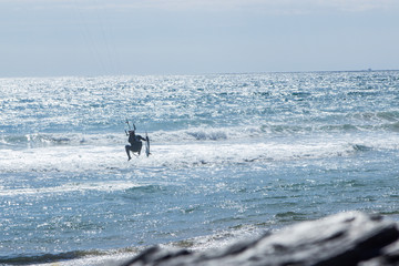 A man kitsurfing in the ocean in a beautiful summer day