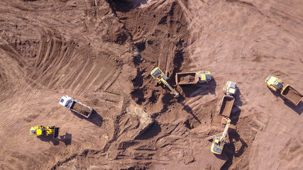 Earthmoving equipment. Aerial view of large construction site with several earthmover machines.