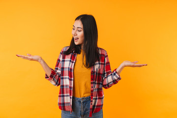 Photo of pleased young woman smiling and holding copyspace