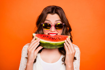 Portrait of cheerful positive cute nice cool youngster biting a wedge of watermelon wearing...