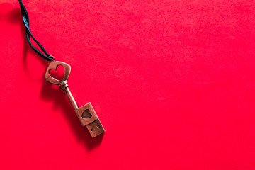Fototapeta na wymiar Key shaped usb stick with heart details on red background