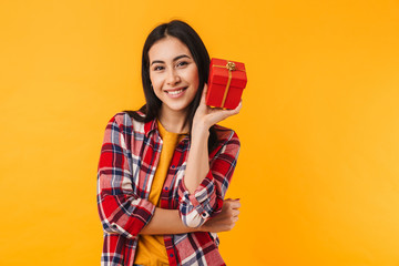 Photo of happy young woman smiling and holding gift box