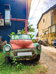 Beautiful image of rusty old vintage car on the house backyard at small indian town