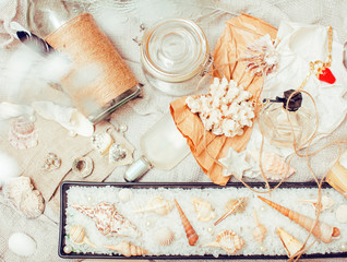 a lot of sea theme in mess like shells, candles, perfume, girl stuff on linen, pretty textured post card view vintage