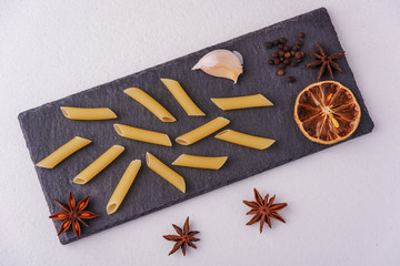 Beautifully stylized pasta decorated with dried lemon and anise on a stone board