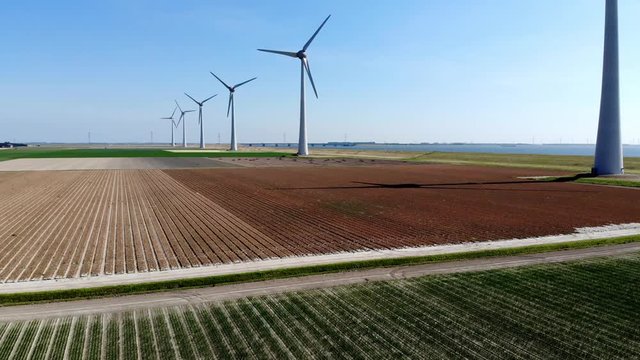 Aerial view of huge steel windmills located in rural area generating green clean power from wind blowing. Alternative electricity generation with friendly technology system. Eco renewable turbines 