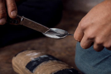 two shabby  men preparing drug injection in slums