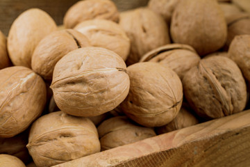 wooden box with raw walnuts isolated on white background