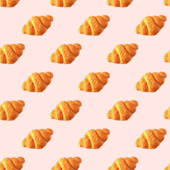Seamless croissant pattern on pastel pink background. 