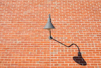 Isolated exterior wall design lighting. Brick wall with exterior halogen lamp. Decorative curved exterior wall lighting.  - 324582258