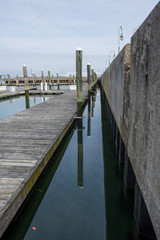 Abstract pier design and detail. Boat pier and walkway. Ocean water cloud reflection.  - 324582677