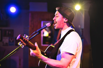 A nice Man playing guitar at a bar