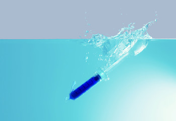 Environmental Pollution Concept.The syringe drop into water.Plastic pollution.Trash drop to the sea. Hazardous waste.Chemical waste.