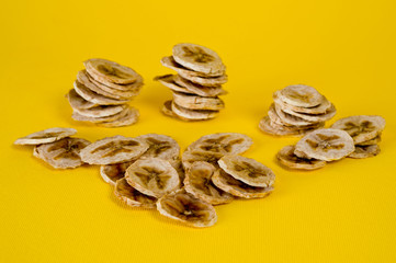 Dried banana chips, sliced in thin circles. Background for healthy and natural nutrition.