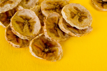Dried banana chips, sliced in thin circles. Background for healthy and natural nutrition.
