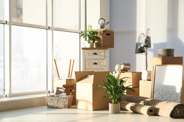 Cardboard boxes and household stuff in living room. Moving day