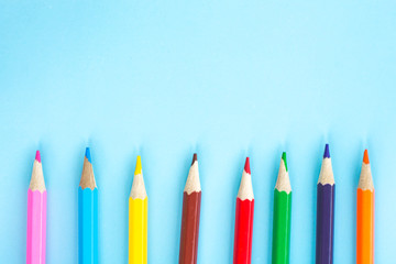 Colored pencils on a bright blue background. The concept of children's creativity.
