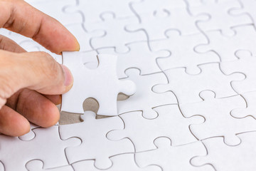Hand holding piece of jigsaw puzzle