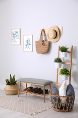 Beautiful plants and comfortable bench near white wall at home. Idea for interior design