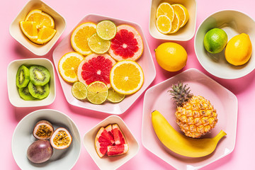 Tropical fruits whole and slices on plates