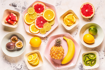 Tropical fruits whole and slices on plates