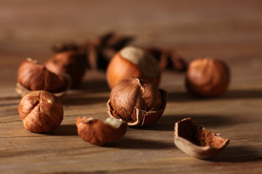 hazelnuts with split shells on a wooden table close-up