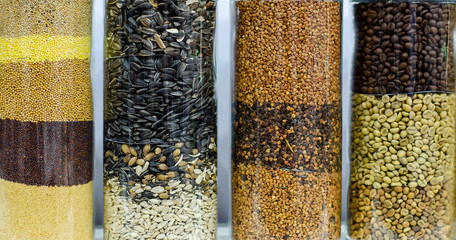 Different seeds and cereals in glass containers