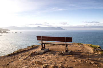 Naklejka na ściany i meble Wooden bench on a cliff