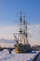 A frigate shackled by ice on the New, in the rays of the setting sun.