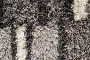 Texture of long-pile carpet with grey, black and white color. Abstract background of a shaggy texture with long fibers