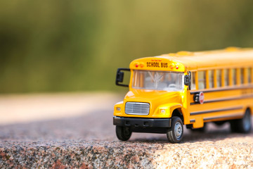 Yellow toy school bus outdoors on sunny day. Student's transport © New Africa