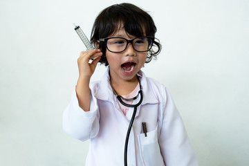 Photo of kid doctor with stethoscope and syringe on white background