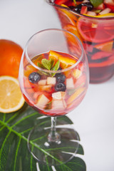 Red wine fresh sangria or punch with fruits, mint leaves and berries. Homemade waffles on the background.