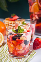 Red wine fresh sangria or punch with fruits, mint leaves and berries.