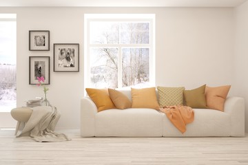 Modern living room in white color with sofa and winter landscape in window. Scandinavian interior design. 3D illustration