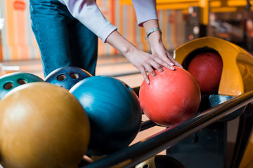 Fototapeta na wymiar cropped view of young woman choosing bowling ball