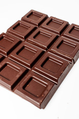 Dark chocolate pieces isolated on white background. Top view.