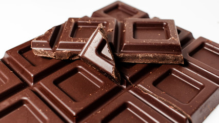 Dark chocolate pieces isolated on white background. Top view.