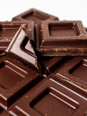 Dark chocolate pieces isolated on white background. Top view.